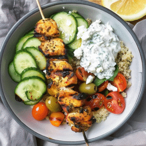 Chicken tzatziki bowl with grilled skewers, quinoa, cucumber, tomatoes, and tzatziki sauce