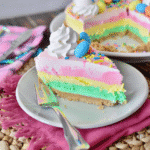 Make This Heavenly Easter No Bake Cheesecake 13 Easter No Bake Cheesecake slice on a plate with pastel layers and mini eggs