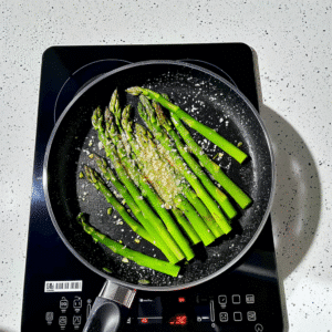 Fresh asparagus spears cooking in pan