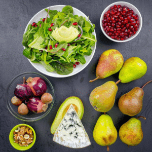 Ingredients for avocado pear salad including gorgonzola, greens, and pears