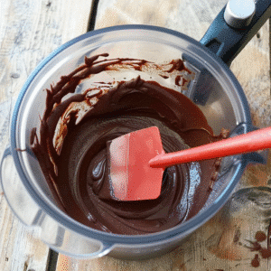 Thick brownie batter with spatula in blender container