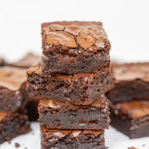 Stack of fudgy cottage cheese brownies on white background