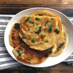 Recipe Green Onion Cakes Made Easy 13 Stack of golden recipe green onion cakes on a white plate