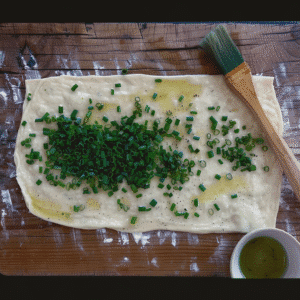Rolled out dough brushed with oil and sprinkled with green onions