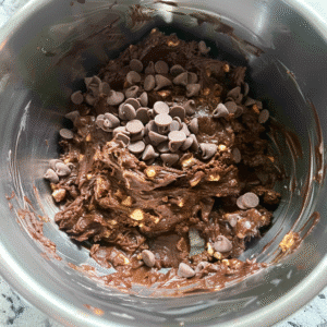 Brownie batter with protein powder and chocolate chips in mixing bowl