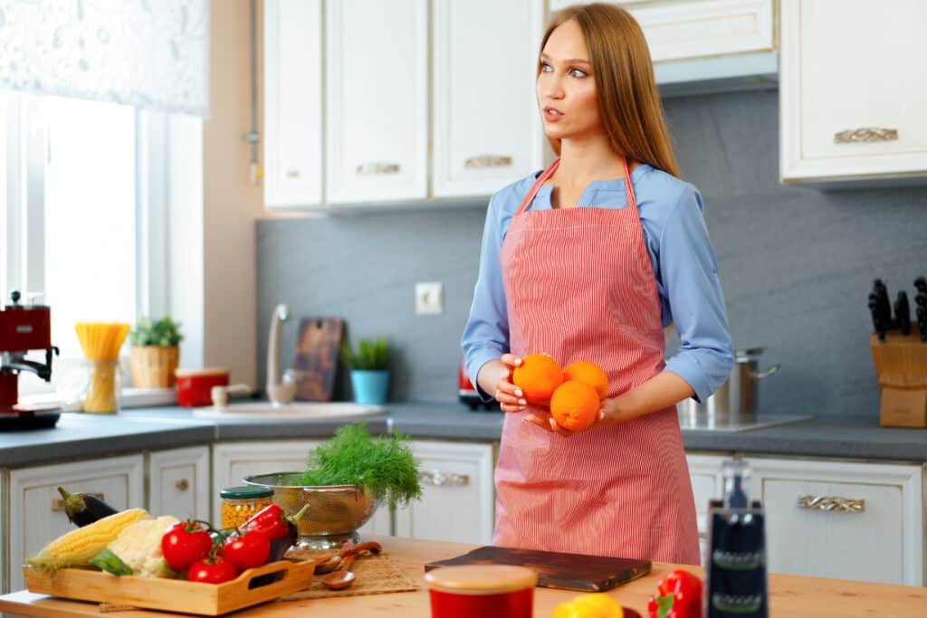 Authors 2 attractive young woman red apron standing her kitchen